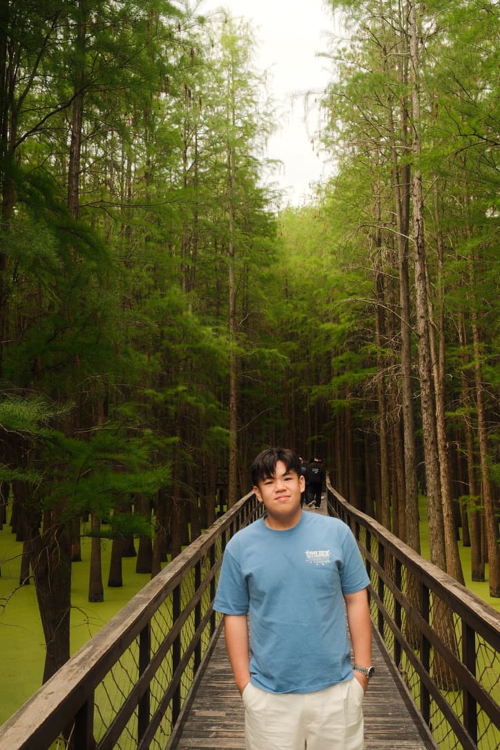 Kenaz on a wooden boardwalk through a flooded cypress forest in Hangzhou