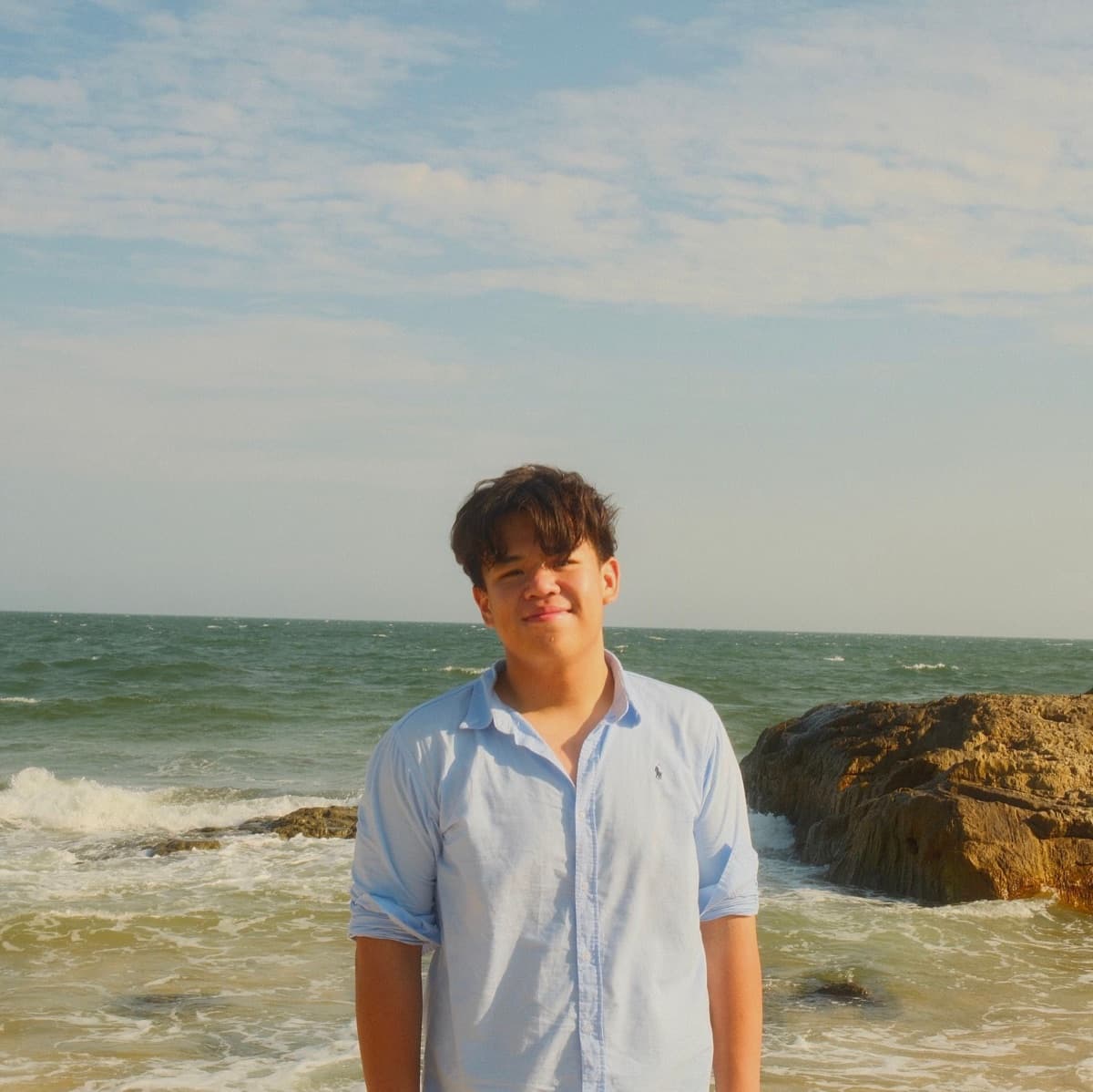 Kenaz on a beach near Ho Chi Minh City, waves breaking on the rocks behind